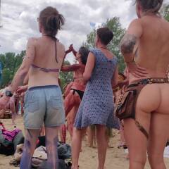 Hippie blonde dancing naked on drums at festival